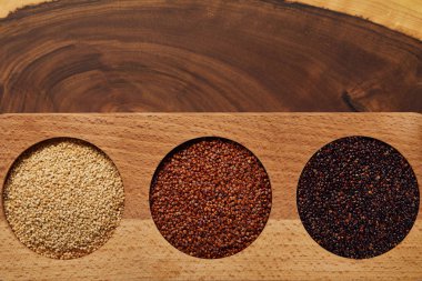 top view of white, black and red quinoa in wooden round bowls clipart