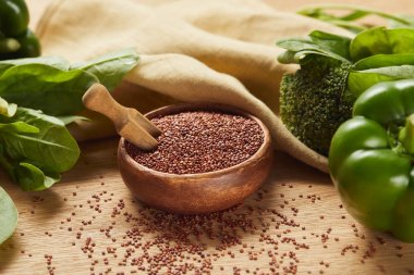 bej peçete ve yeşil sebzeler yakınında spatula ile ahşap kase kırmızı Quinoa