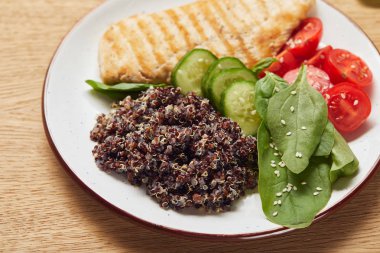 close up view of cooked quinoa with grilled chicken breast and vegetables on white plate clipart