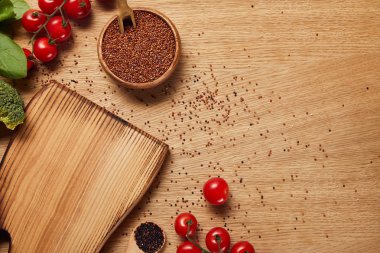 doğrama tahtası ve kırmızı domates yakın ahşap kase kırmızı Quinoa tohumları üst görünümü