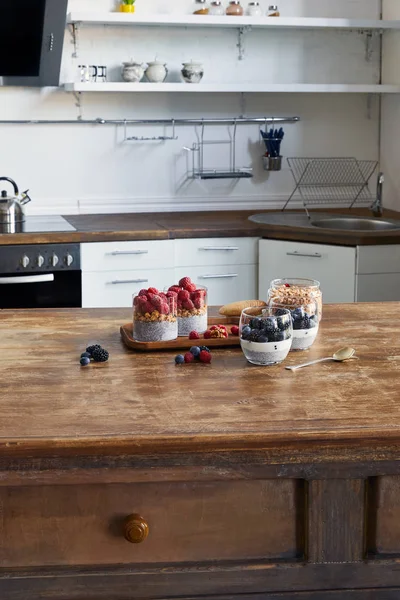 美味的酸奶与嘉种子和浆果在厨房的木托盘玻璃 — 图库照片