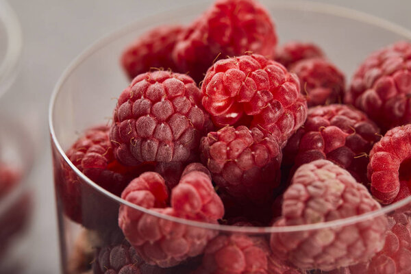 close up view of fresh tasty raspberries in glass