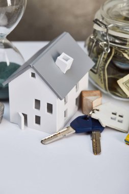 anahtar ve moneybox, gayrimenkul konsepti ile beyaz masa üzerinde ev modeli
