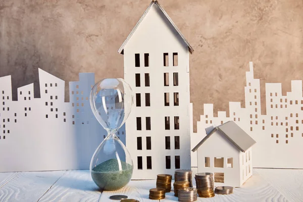 Häuser Modelle Und Sanduhr Auf Weißem Holztisch Mit Münzen Immobilienkonzept — Stockfoto