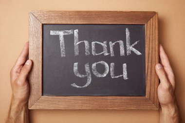 cropped view of man holding chalkboard with thank you lettering clipart