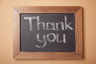 chalkboard with thank you lettering on beige background clipart