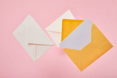 pembe arka planda boş beyaz kartlı zarflar