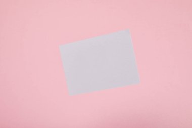 pembe arka planda boş beyaz kart üst görünümü