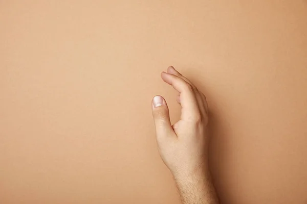 Vista Recortada Mano Masculina Sobre Fondo Beige Con Espacio Copia —  Fotos de Stock