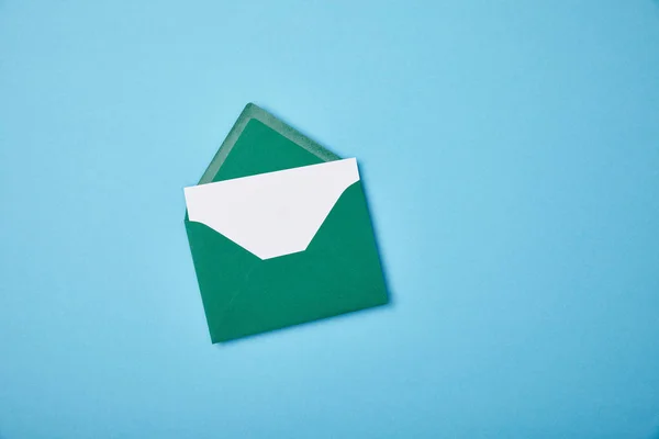 Zielona Koperta Pustą Białą Kartą Niebieskim Tle — Zdjęcie stockowe