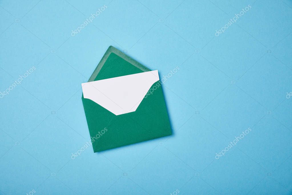 Green envelope with blank white card on blue background