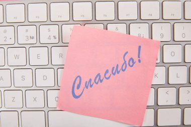 Laptop klavyesi Rusça minnettar yazı ile pembe yapışkan not üst görünümü 