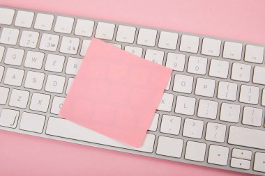 top view of empty pink sticky note on laptop keyboard on pink background clipart