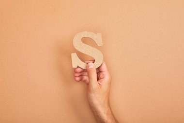 bej arka planda adam tutan kağıt kesme harfi S kırpılmış görünümü