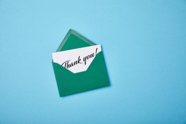 green envelope and white card with thank you letting on blue background clipart