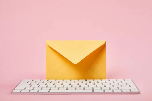 Gele Envelop Buurt Van Witte Computer Toetsenbord Roze Achtergrond — Stockfoto