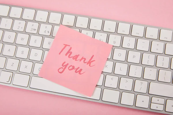 粉红粘滞便笺的顶视图与感谢词在粉红色背景的笔记本电脑键盘 — 图库照片