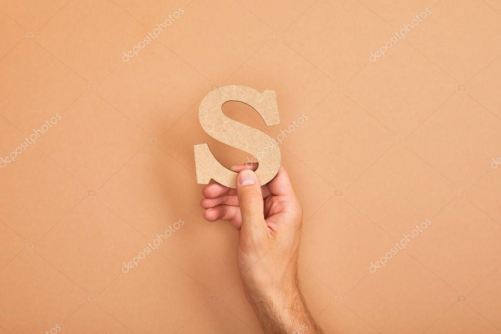 Cropped view of man holding paper cut letter S on beige background