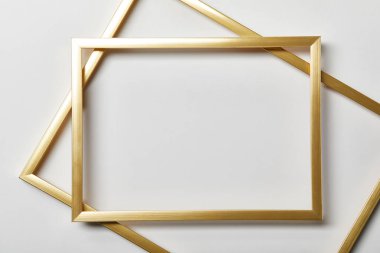 top view of empty golden frames on white background with copy space clipart
