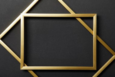 top view of empty golden frames on black background clipart