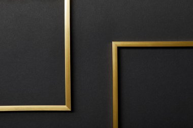top view of empty golden frames on black background with copy space clipart