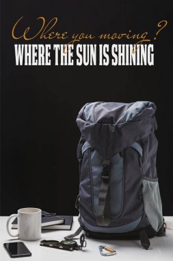 sırt çantası, fincan, dizüstü bilgisayarlar, akıllı telefon ve trekking ekipmanları siyah üzerinde izole nerede soru hareketli ve nerede güneş parlıyor cevap