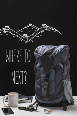 backpack, cup, notebooks, smartphone and trekking equipment isolated on black with where to next question clipart