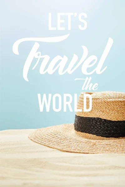 选择性焦点草帽在夏天的金沙上孤立在蓝色上 让旅行世界插图 — 图库照片