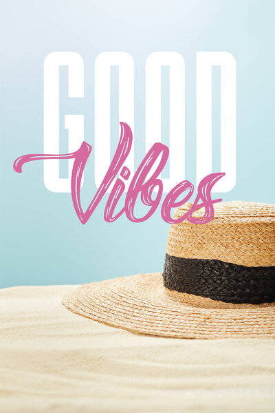 selective focus of straw hat on golden sand in summertime isolated on blue with good vibes illustration