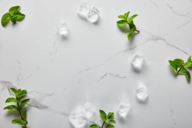 top view of green fresh mint and ice cubes on marble surface clipart