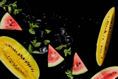 top view of red and yellow watermelon slices with mint and ice isolated on black clipart