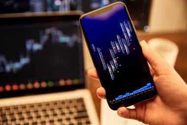 grafikler ve grafikler ile akıllı telefon tutan adam kırpılmış görünümü 