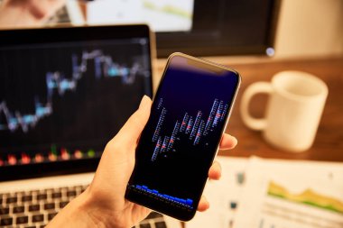 grafikler ve grafikler ile akıllı telefon tutan adam kırpılmış görünümü 