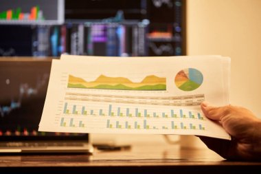 cropped view of adult man holding papers with charts and graphs  clipart
