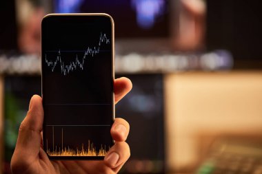grafikler ve grafikler ile akıllı telefon tutan adam kırpılmış görünümü 
