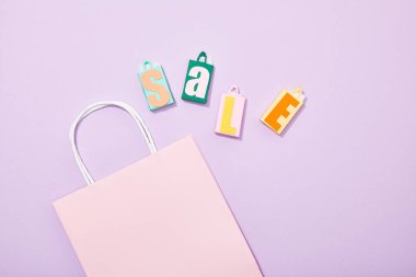 menekşe üzerinde pembe alışveriş çantası yakınında satış yazıt ile oyuncak çanta üst görünümü