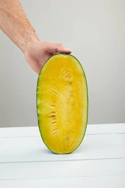 Partial View Man Holding Ripe Yellow Watermelon Half Wooden Table — Stock Photo, Image