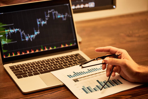 обрезанный вид взрослого мужчины, держащего очки в офисе
 