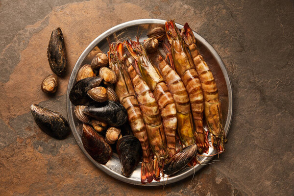 top view of shellfish with cockles and mussels in bowl on textured surface 