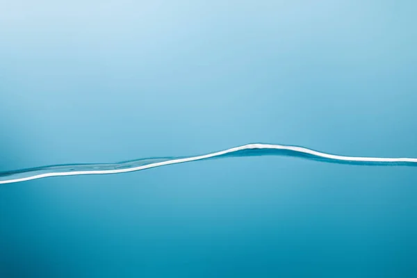 smooth calm transparent pure water on blue background