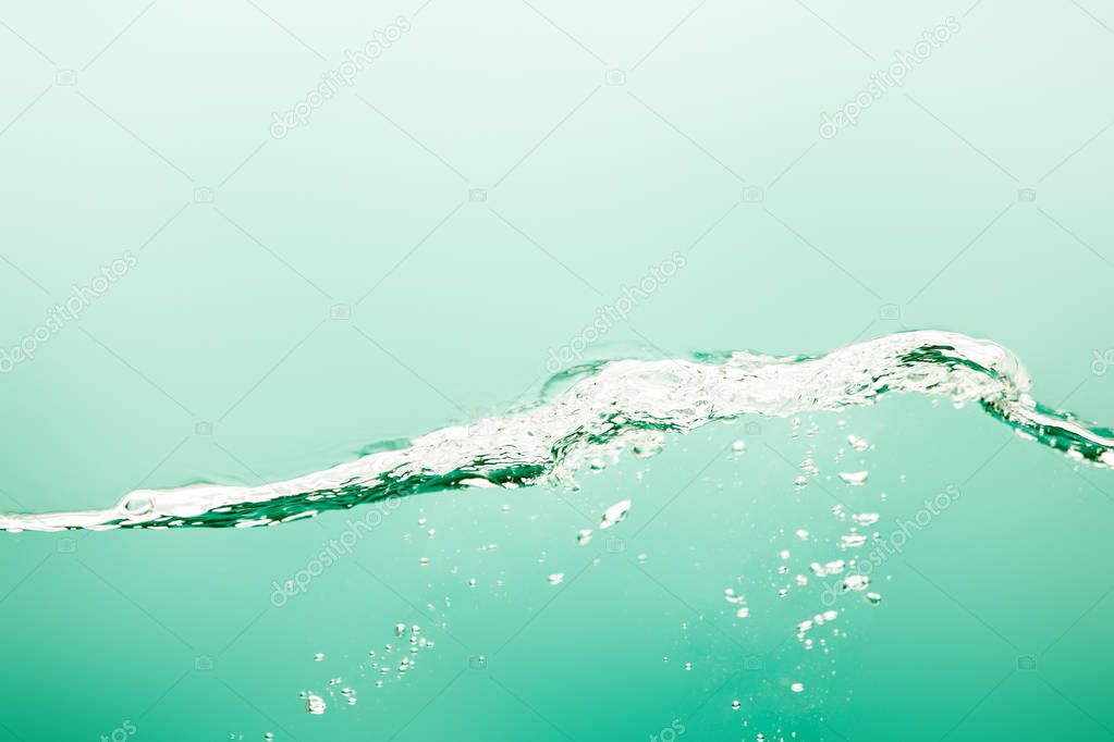 transparent pure water with splash and bubbles on green background