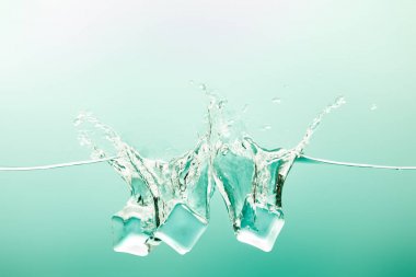 transparent pure water with splash and ice cubes on green background clipart