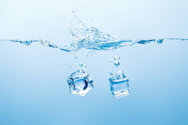 pure water with splash and ice cubes on blue background