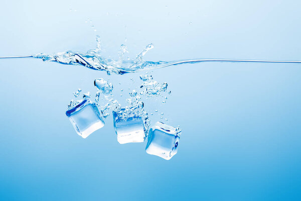 transparent pure water with splash and ice on blue background