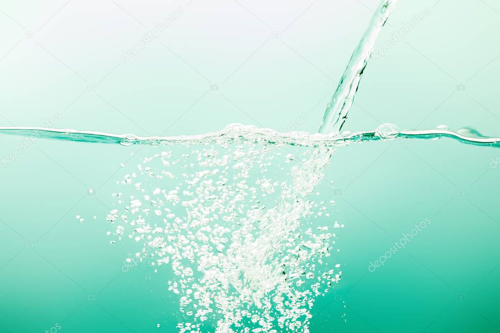 transparent pure water with stream and bubbles on green background