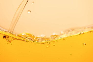 pouring yellow bright liquid with splash and bubbles isolated on yellow clipart