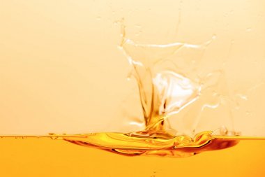 yellow bright liquid splash with drops isolated on yellow clipart