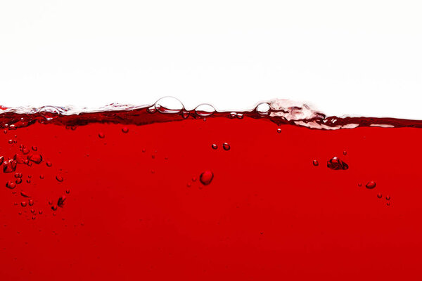 красная красочная жидкость с пузырьками на поверхности, изолированные на белом
