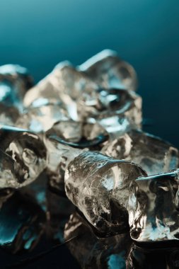 close up view of clear ice cubes on emerald background clipart