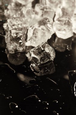 stack of transparent cool ice cubes on black background with drops clipart